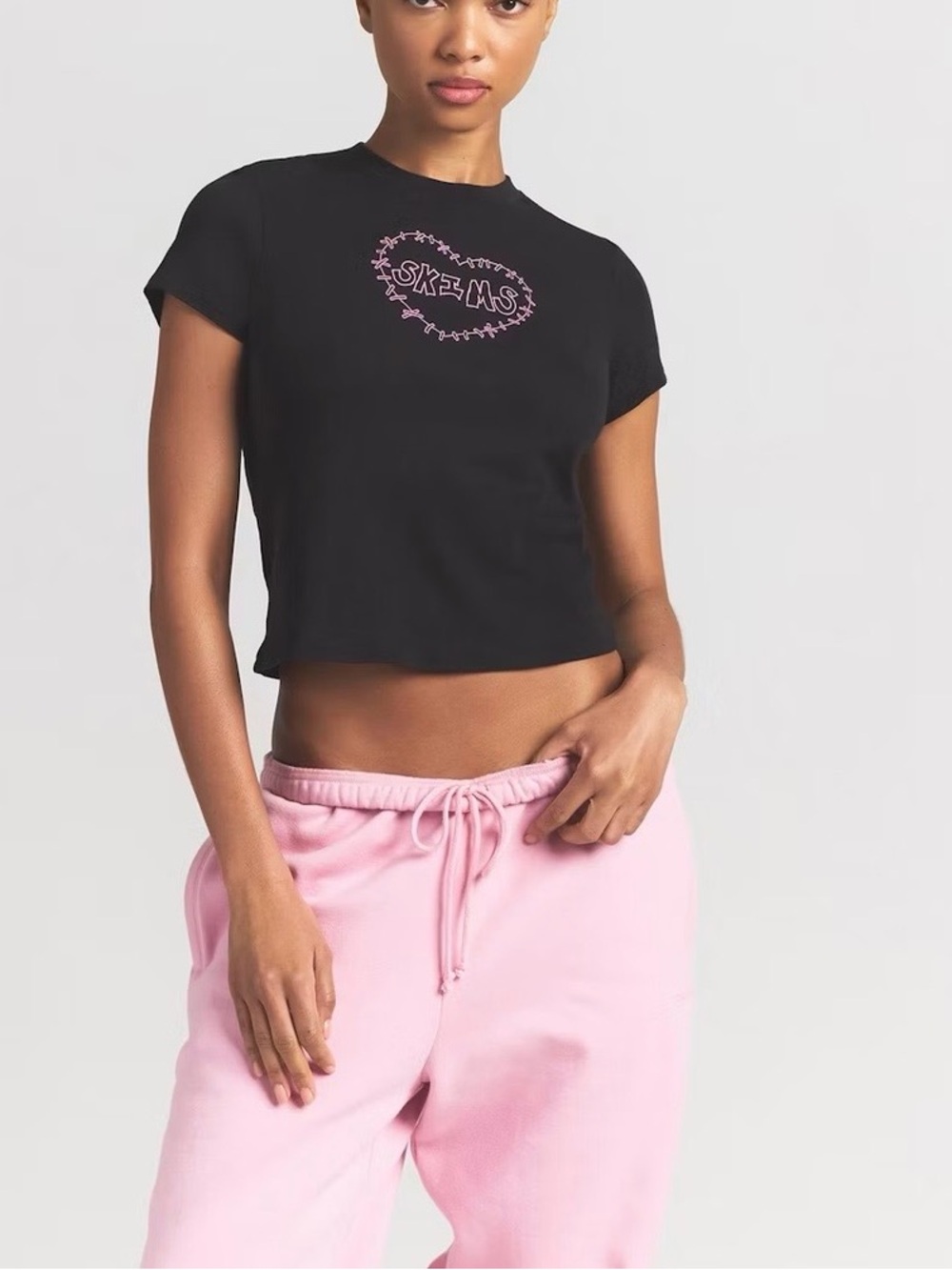 SKIMS Black baby t shirt with Pink Logo.